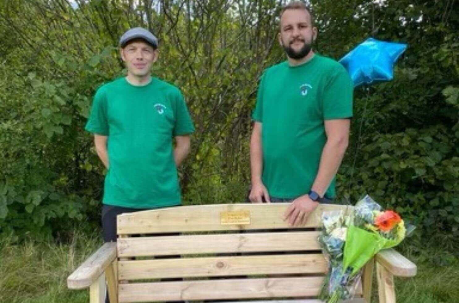 Companion Simon and Projects Manager Phil stand next to the bench presented to Tom's mum Noreen Parker at Seven Acres in Bolton