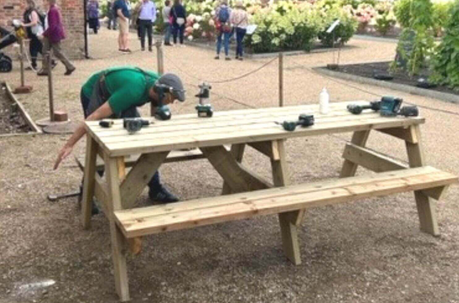 Companion Simon assembling picnic tables he made at RHS Bridgewater, supported by Projects Manager Phil