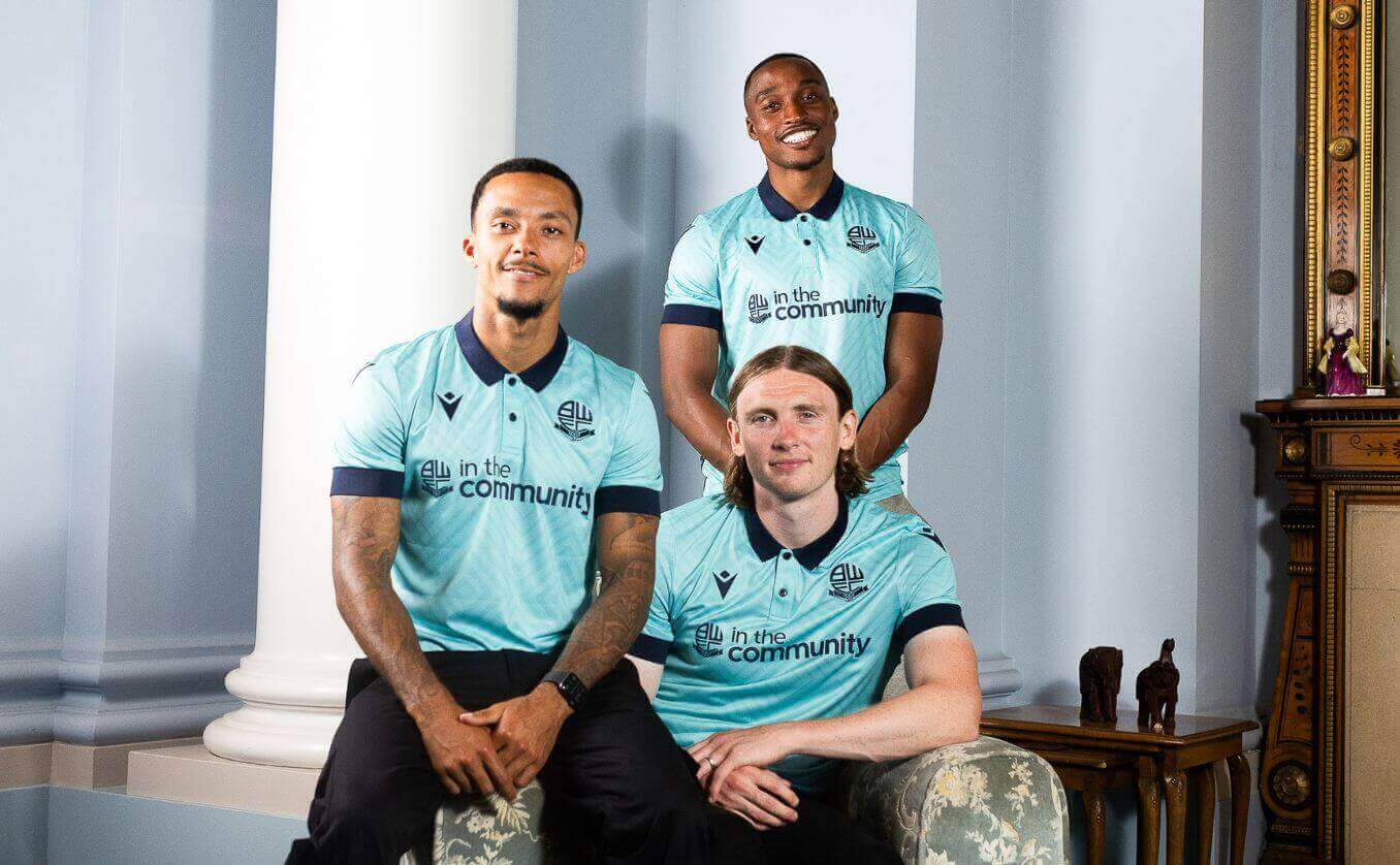 Bolton Wanderers first team players Victor Adeboyejo, Jón Daði Böðvarsson and Joshua Dacres-Cogley in the third kit featuring Emmaus.