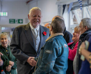 Sir Terry Waite is greeted by people at Emmaus Greenwich.