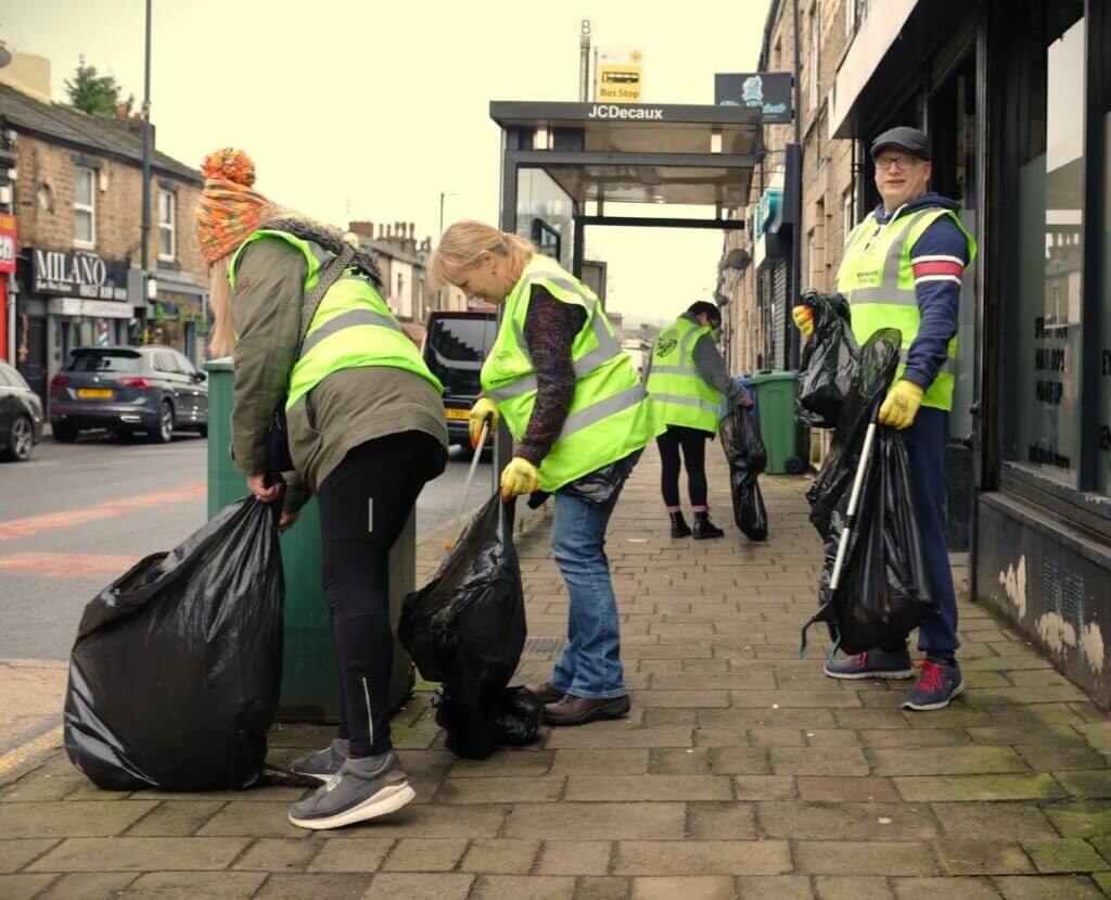 Four people take part in a litter pick outside some shops as part of the Day of Action.